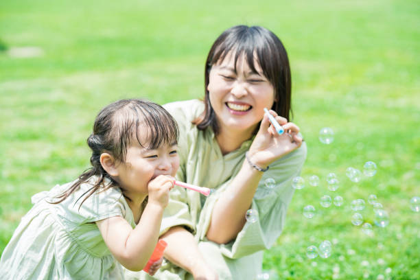 istock mother and her daughter playing with soap bubbles 1403097855