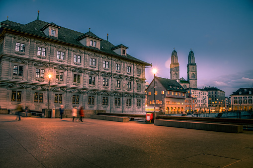 View Of Fraumunster Church In Zurich At Night, Switzerland. The building on the left is Zurich Town Hall building.