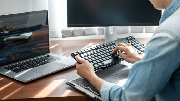 istock Asian woman programmer looking on keyboard to typing code data about new project on laptop while working 1403099867