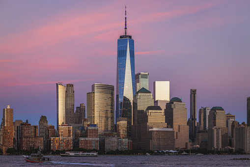 Lower Manhattan and the Freedom Tower under a colorful sunset in summer.