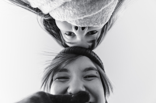 A graysca shot of an excited Caucasian little girl posing for the camera