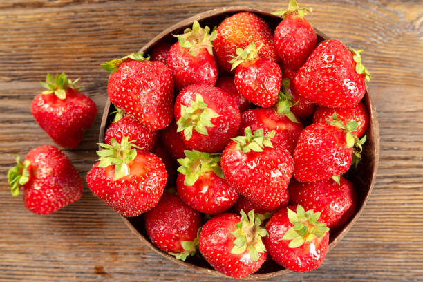 istock Fresh red strawberry on a brown wooden background. 1403101353