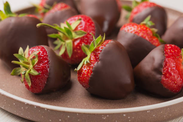 istock Gourmet chocolate covered strawberries on ceramic plate. Dessert background.  Selective focus. 1403103638