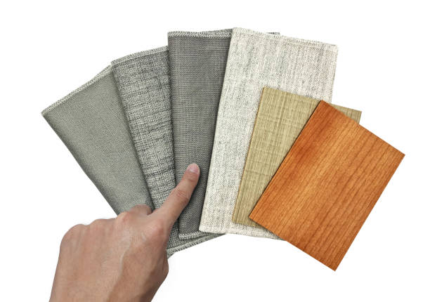 istock designer's hand choosing material from various texture of drapery fabric samples swatch in grey tone matching color with oak, ash wooden veneer samples isolated on white background with clipping path. 1403103928