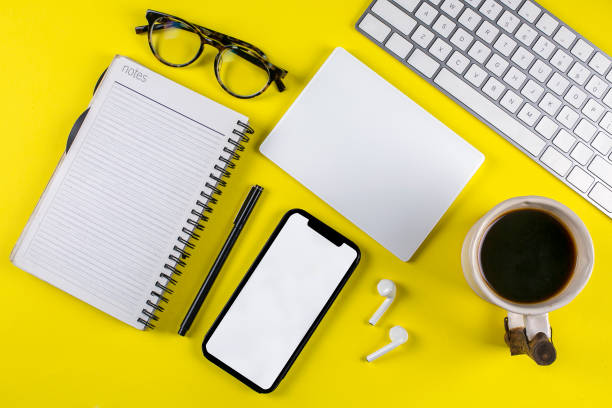 Office desk on yellow background with copy space.