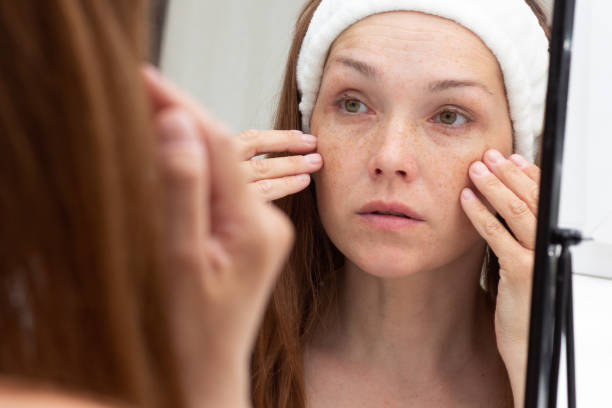 istock Woman looking at wrinkles in mirror 1403106853