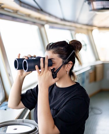 Young and beauty walkie-talkie in handful female ship captain with binoculars and