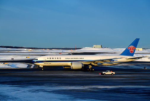 Anchorage, Alaska, USA: China Southern Airlines Boeing 777-F, registration B-20EN - MSN 65422 - near a snowplow - winter at Ted Stevens Anchorage International Airport.