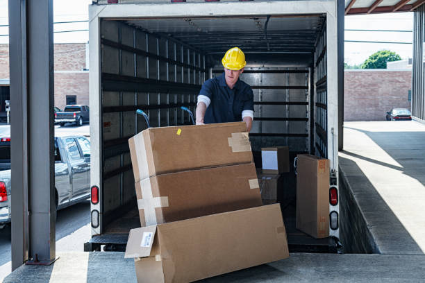 istock Delivery Worker Stacking Cardboard Cartons on Hand Truck 1403109546