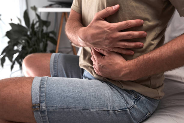 hombre con dolor de estómago y problemas digestivos. - rib cage fotografías e imágenes de stock