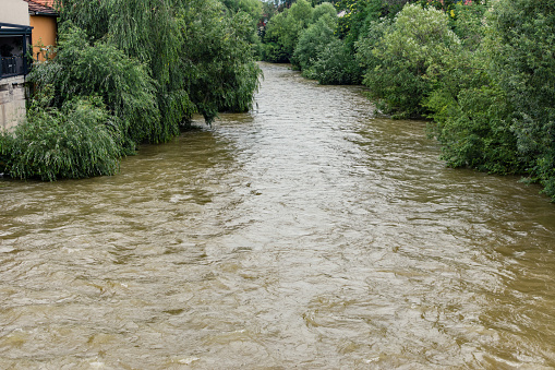 Dirty water of a rising river in an urban area. Flood concept