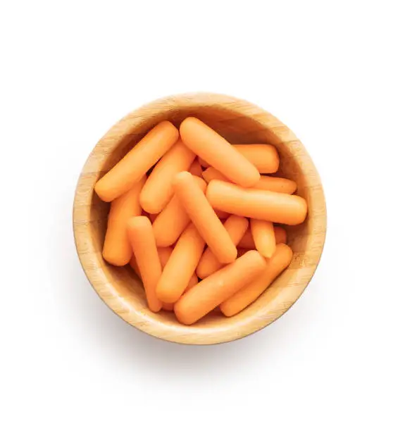 Photo of Baby carrot vegetable. Mini orange carrots isolated on white background.