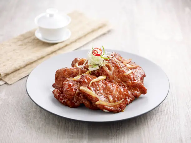 Imperial Sweet and Sour Pork Ribs with chopsticks served in a dish isolated on mat side view on grey background
