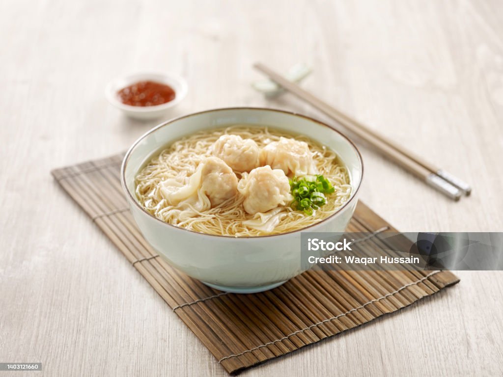 Signature Canton Jumbo Prawn Wanton Noodle with chopsticks served in a bowl isolated on mat side view on grey background Appetizer Stock Photo