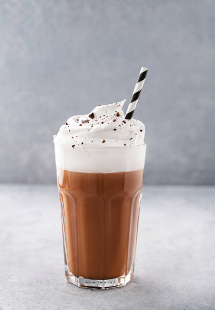 istock Hot chocolate with whipped cream in a tall glass on a blue background. Front view and copy space 1403123397