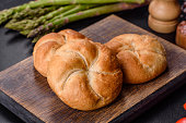 Crusty round bread rolls, known as Kaiser or Vienna rolls on a cutting board
