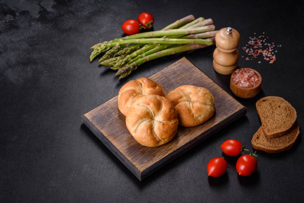 istock Crusty round bread rolls, known as Kaiser or Vienna rolls on a cutting board 1403123459