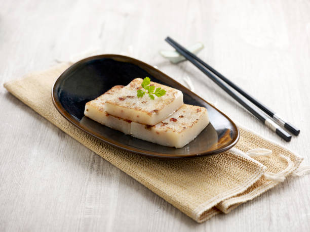 istock Pan-fried Radish Cake Served in a dish isolated on wooden board side view on grey background 1403124578