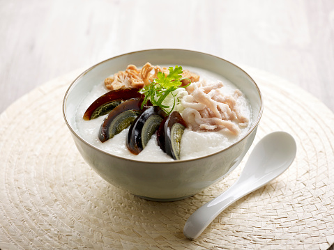 Century Egg and Shredded Pork Congee served in a dish isolated on mat side view on grey background