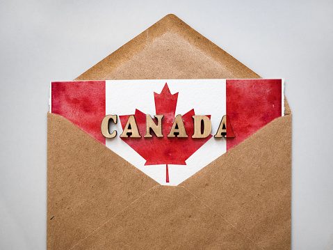 Happy Canadian Day. Postal envelope painted in the national colors of the Canadian Flag. Holiday concept. Closeup, top view, texture. Congratulations for family, relatives, friends and colleagues