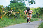 istock Young rider kid in helmet and sunglasses riding bicycle 1403126247