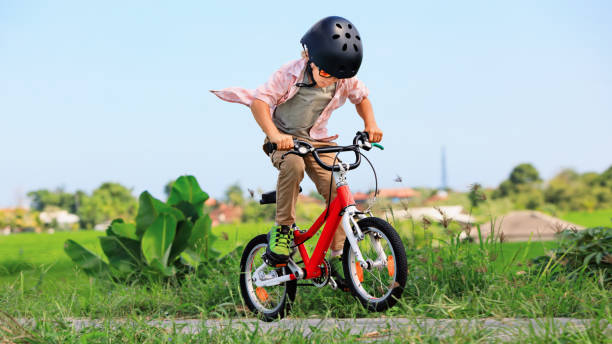 joven jinete niño en el casco y gafas de sol montar en bicicleta - bmx cycling bicycle cycling sport fotografías e imágenes de stock