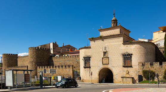 View of Puerta de Trujillo, medieval brick building in city wall of Plasencia used as gate to old district and as Catholic chapel on sunny spring day. Historical monument of Spain