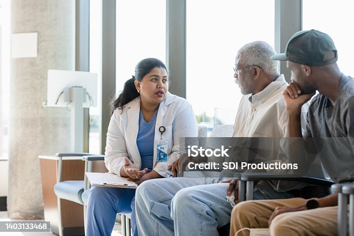 istock Senior man and his son listen to female doctor 1403133468