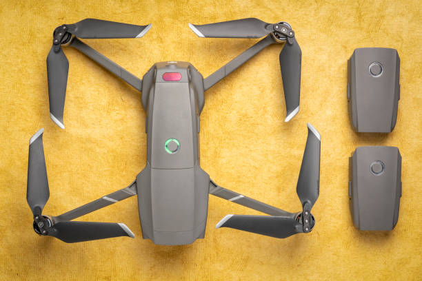 DJI Mavic 2 pro drone with spare batteries Fort Collins, CO, USA - March 10, 2019 Overhead view of DJI Mavic 2 pro drone with two spare batteries against textured handmade paper. drone battery stock pictures, royalty-free photos & images