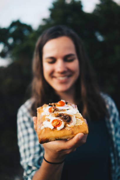 istock Young woman eats fresh bread with cheese and tomatoes 1403139403