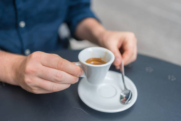 Young man enjoys an espresso at an outdoor cafe stock photo