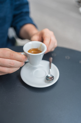 Closeup image of a woman and a man clinking coffee cups together in cafe