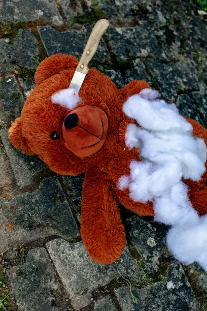 istock teddy bear lying on the floor destroyed with a knife 1403140188