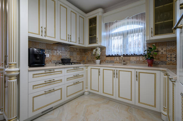 a black and white kitchen with marble counter tops on the island in front of the sink is seen through an open door