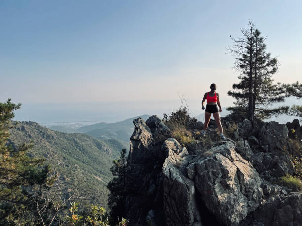 istock Young woman hikes up arid mountain side through forest 1403141023
