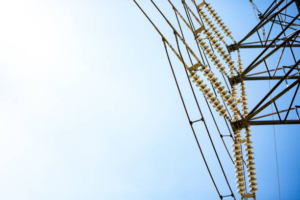 Closeup High voltage Electricity pylon with powerlines and insulators, background with copy space, full frame horizontal composition