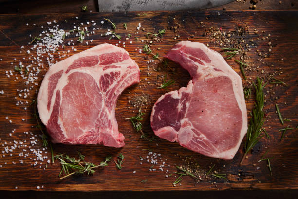Seasoning Raw Pork Chops stock photo
