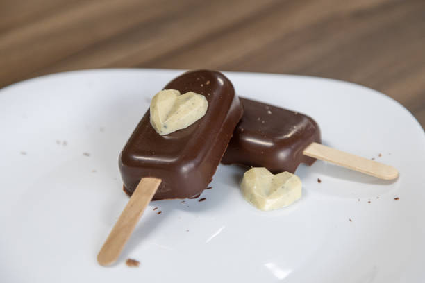 istock Two Heart shaped chocolate cake pops on a white plate. Wooden table background 1403144308