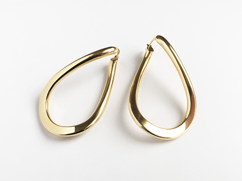 Gold earrings on the white background