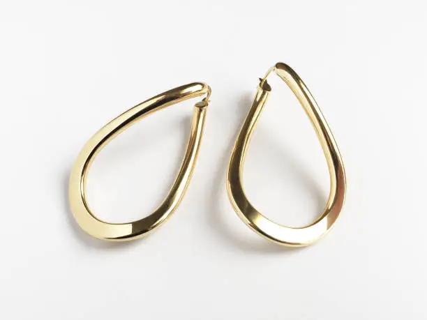 Gold earrings on the white background