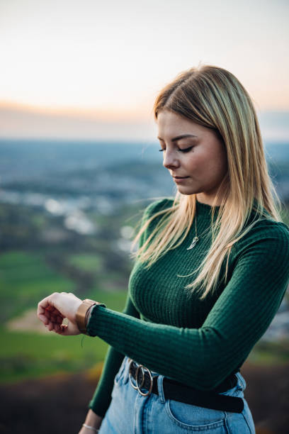 Young Blond Woman Outdoors Checking Modern Smart Watch stock photo