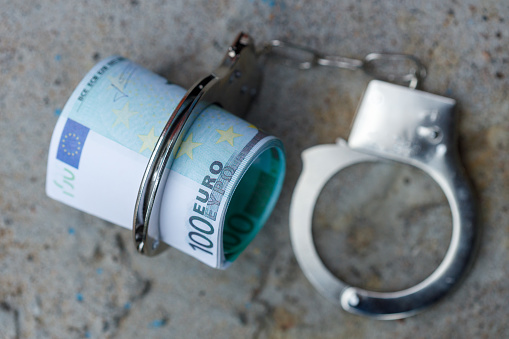 a pack of one hundred euro banknotes in handcuffs. High quality photo