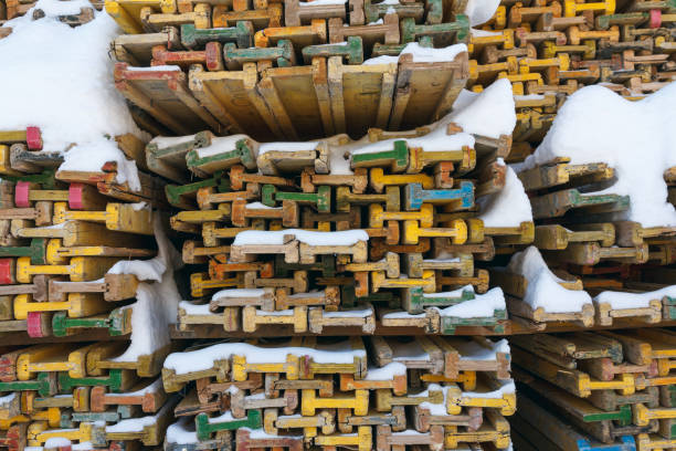 Wooden piled formwork beams under the snow. Equipment for concrete work at a construction site. Formwork. Formwork for monolithic construction.