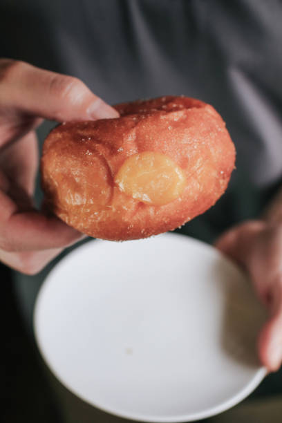 istock Hand pick doughnuts with Creamy Lemon Filling Dusted on white plate. copy space for your text. Snack food and dessert. 1403156467