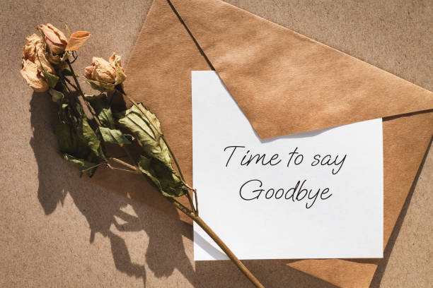 istock Time to say goodbye note, envelope and dry roses 1403168341
