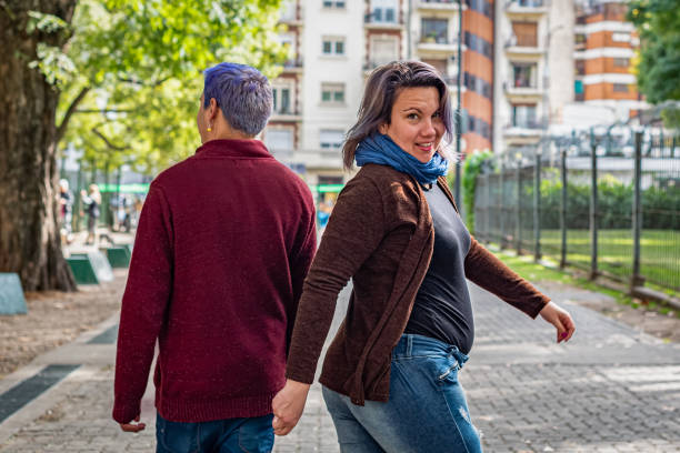 istock Back view of two friends walking in the park. 1403169947
