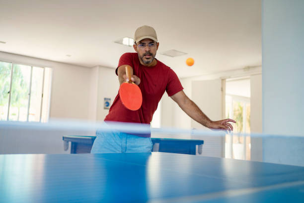homem maduro jogando tênis de mesa - tennis men indoors playing - fotografias e filmes do acervo