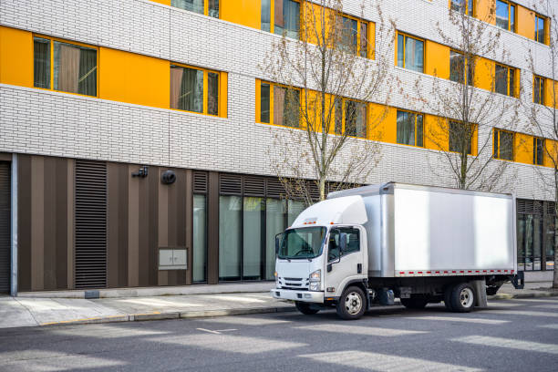 pequeña cabina compacta sobre camión con remolque de caja que entrega carga a apartamentos urbanos de varios niveles en la ciudad - small truck fotografías e imágenes de stock