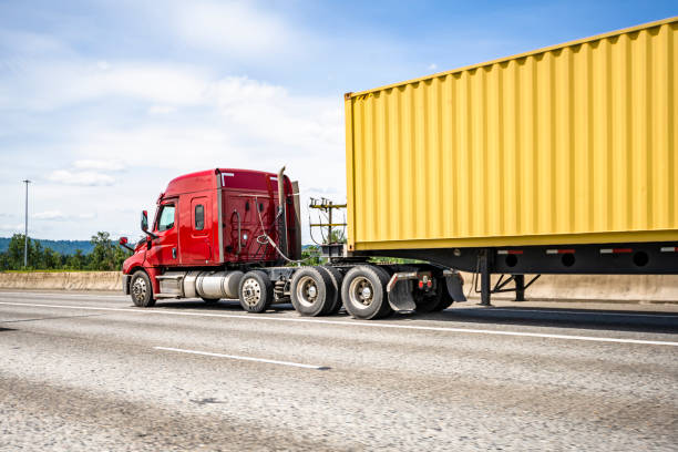 istock Low cab profile red big rig semi truck transporting cargo container on semi trailer running on the highway road 1403175069
