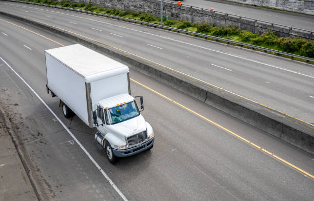 potente semicarro compatto di dimensioni di meddle con rimorchio box che guida sulla strada autostradale con intersezione di uscita - furgone pickup foto e immagini stock